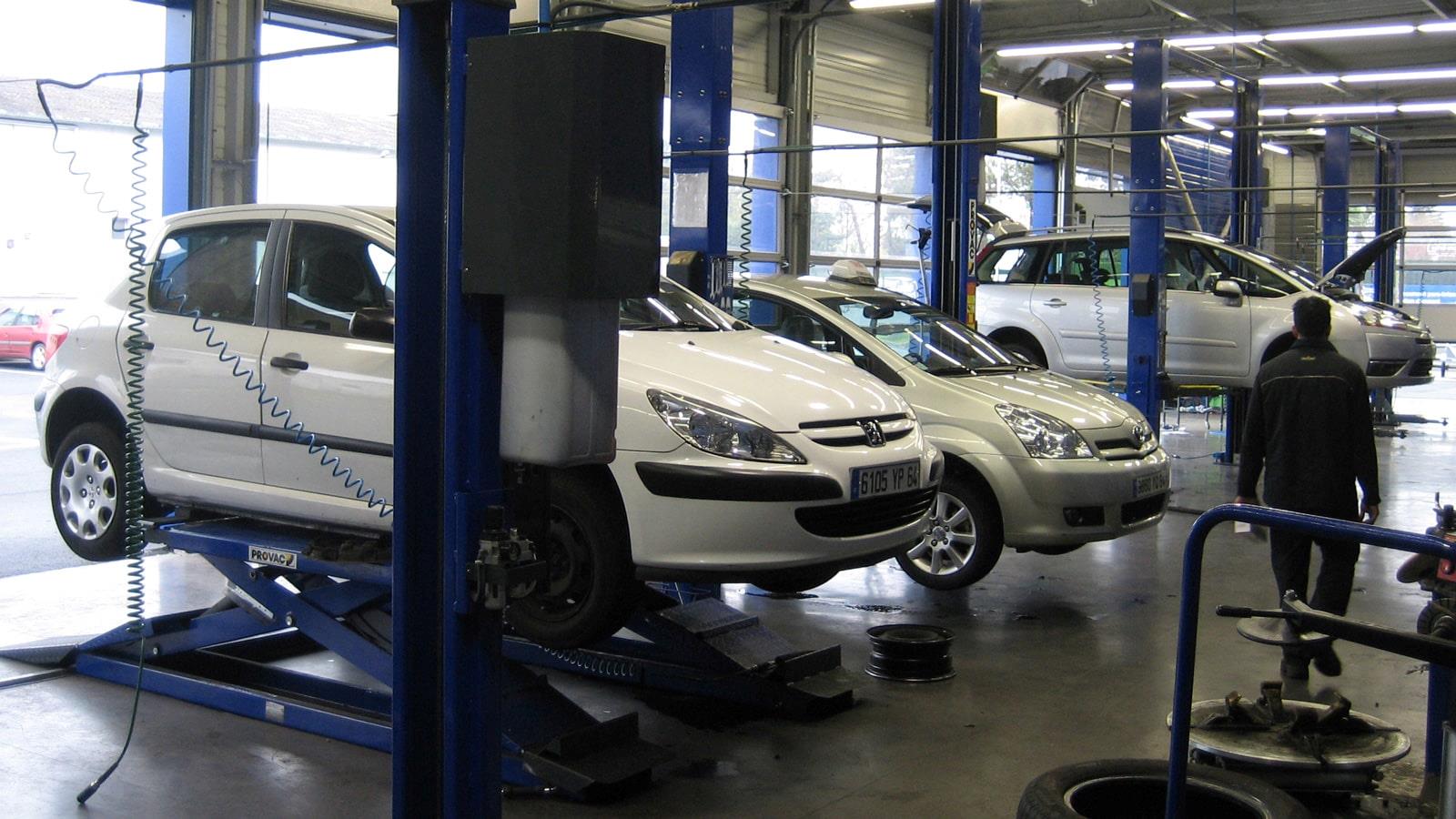 Cars hoisted up for inspection by Norauto mechanics 