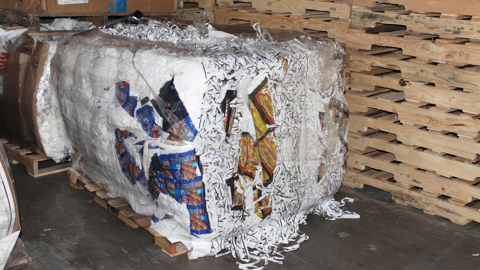 Compacted bale of shredded plastic placed on a pallet
